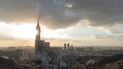 Timelapse of sunset over the Royal Clock Tower in Mecca, architectural art of skyscrapers, sacred Islamic religious landmark, the House of God in the Grand Mosque in Mecca, Saudi Arabia, worship and drawing closer to God