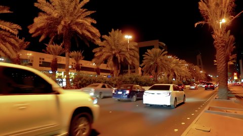 Traffic and transportation at night, aerial drone footage of King Fahd Road in the capital of Saudi Arabia, the growth and development of infrastructure in Riyadh, and the architectural art of towers, residential and commercial buildings.