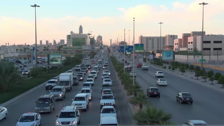 Daytime traffic, aerial drone footage of King Fahd Road in the capital of Saudi Arabia, the growth and development of infrastructure in Riyadh, and the architectural art of towers, residential and commercial buildings.
