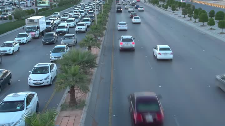 Daytime traffic, aerial drone footage of King Fahd Road in the capital of Saudi Arabia, the growth and development of infrastructure in Riyadh, and the architectural art of towers, residential and commercial buildings.