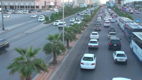Daytime traffic, aerial drone footage of King Fahd Road in the capital of Saudi Arabia, the growth and development of infrastructure in Riyadh, and the architectural art of towers, residential and commercial buildings.