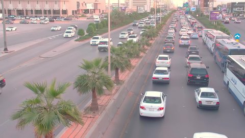 Daytime traffic, aerial drone footage of King Fahd Road in the capital of Saudi Arabia, the growth and development of infrastructure in Riyadh, and the architectural art of towers, residential and commercial buildings.