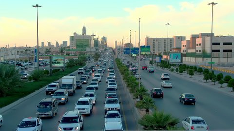 Daytime traffic, aerial drone footage of King Fahd Road in the capital of Saudi Arabia, the growth and development of infrastructure in Riyadh, and the architectural art of towers, residential and commercial buildings.