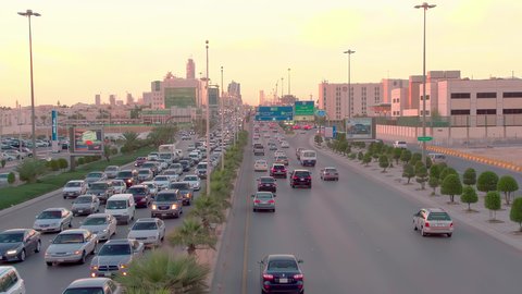 حركة وسائل النقل والمواصلات في النهار، تصوير درون جوي لطريق الملك فهد في عاصمة المملكة العربية السعودية، نمو وتطور البنية التحتية في مدينة الرياض، الفن الهندسي المعماري للأبراج والمباني السكنية والتجارية