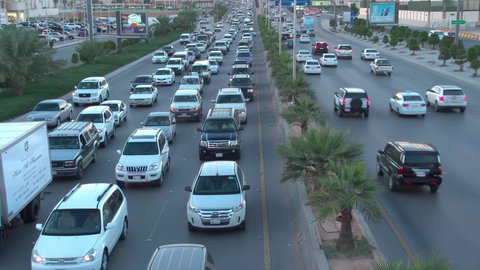 Daytime traffic, aerial drone footage of King Fahd Road in the capital of Saudi Arabia, the growth and development of infrastructure in Riyadh, and the architectural art of towers, residential and commercial buildings.