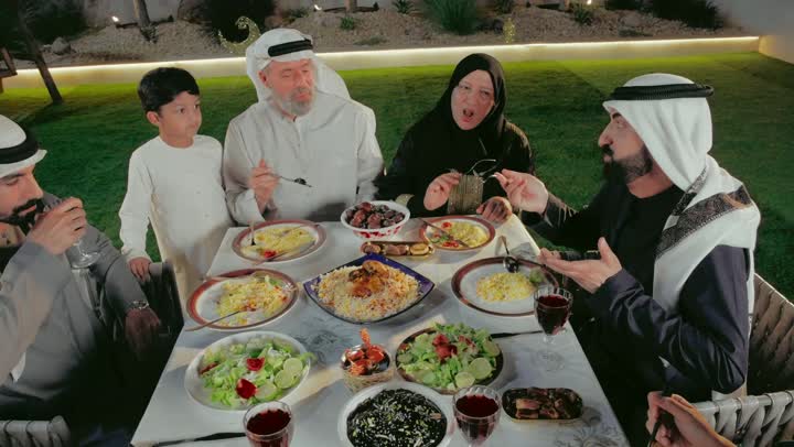 تجمع عائلي في شهر رمضان , مأكولات صحية على مائدة الافطار,أجواء رمضانية روحانية, المناسبات الاسلامية و الدينية، عائله عربيه خليجيه اماراتية تقوم بتناول وجبه الافطار بايماءات السعادة و السرور، نقاشات وحوارات عائلية