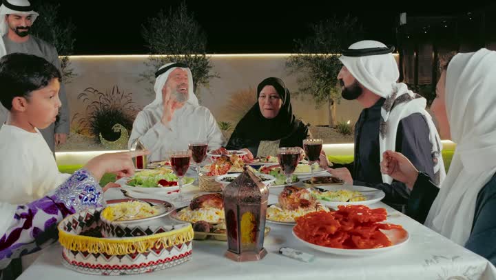 قضاء وقت ممتع في الاستراحة فى الامارات العربية, الزيارات والتجمعات الأسريه ,تصوير مقرب لرجل عربي سعودي اماراتي يرتدي الزي التقليدي يقوم بتقبيل رأس والده, أجواء عائليه سعيده, المناسبات والاعياد الاسلاميه