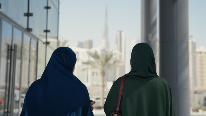 متعة مشاركة الأصدقاء في اختيار الهدايا من المراكز التجارية، الأثر الإيجابي للتسوق على النساء، إمرأتان عربيتان خليجيتان سعوديتان تحملان الأكياس الورقية تقومان بالتبضع، سيداتان اماراتيتان تتبادلان الاحاديث والاخبار، الاستفادة من حسومات الجمعة البيضاء