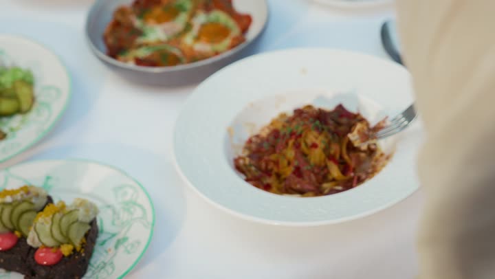 A table full of delicious food, a close-up shot from above of a veiled Emirati Gulf Arab woman wearing casual clothes sitting at a table, restaurants and cafes in the Emirates, gestures of happiness and pleasure, enjoying recreational activities, having a good time outside, having lunch at a restaurant