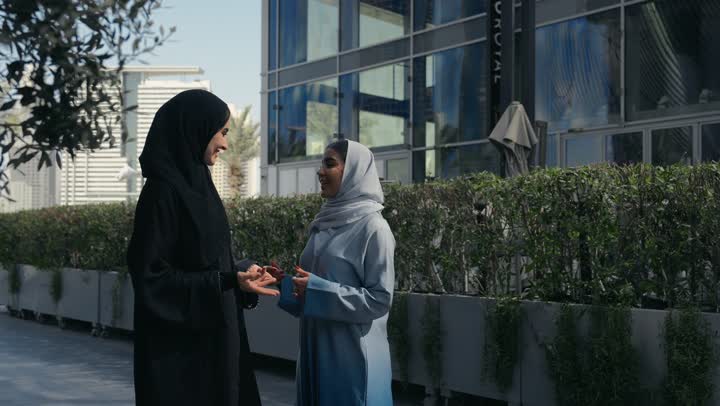 Having fun with friends, two Saudi Arabian Gulf friends enjoying chatting, discussions and dialogues, two Emirati women enjoying chatting and happy gossip, discussions and friends' talk