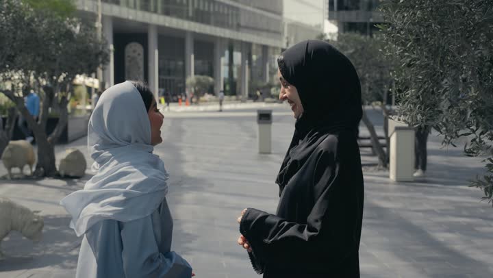 Having fun with friends, two Saudi Arabian Gulf friends enjoying chatting, discussions and dialogues, two Emirati women enjoying chatting and happy gossip, discussions and friends' talk