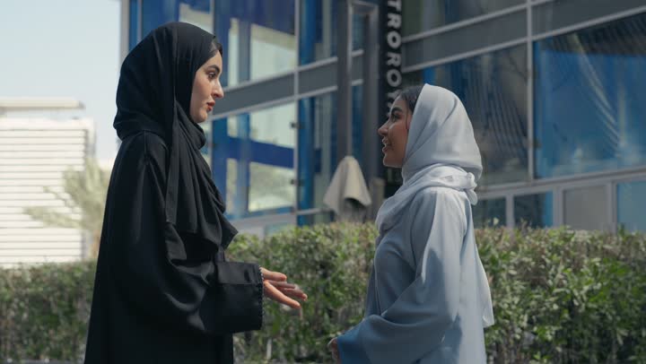 Friendships, acquaintances and having a good time, two Saudi Arabian Gulf friends enjoying exchanging talk, discussions and dialogues, two Emirati women enjoying talking and happy gossip