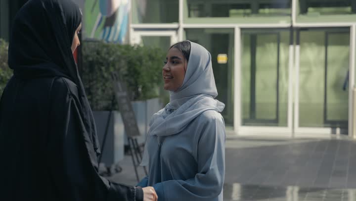 Friendships, acquaintances and having a good time, two Saudi Arabian Gulf friends enjoying exchanging talk, discussions and dialogues, two Emirati women enjoying talking and happy gossip