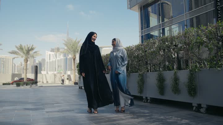 Discussions and talk of friends, gesture of pleasure in the company of friends, spending a pleasant time with friends, two Saudi Arabian Gulf friends enjoying exchanging talk, discussions and dialogues, two Emirati women enjoying talking and happy gossip