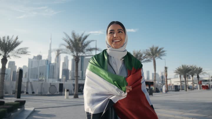 Emirati Gulf Arab woman carrying the UAE flag on her back, celebrating UAE National Day, UAE National Day 51 identity, UAE Independence Day, love of the homeland, UAE National Day, pride and honor