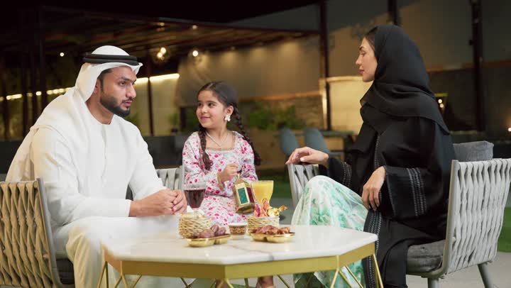 ايماءات السعادة بقدوم رمضان، قضاء وقت ممتع في جلسة خارجية عائلية في احدى الشاليهات، زينة واكسسوار الأعياد والمناسبات الاسلامية، فتاة عربية خليجية اماراتية تحمل بيدها فانوس معدني مزخرف مضيء بجانب والديها، ضيافة شهر رمضان المبارك، أجواء ليلية رمضانية روحانية