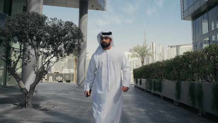 سماع الاخبار والمفاجأت السعيدة، الدردشة والتواصل مع العائلة ، نزهه في الهواء الطلق، إجراء مكالمه هاتفيه عبر الهاتف المحمول، رجل عربي خليجي اماراتي يقضي أوقات ممتعة في إحدى الحدائق في الامارات, جولة في الطبيعة