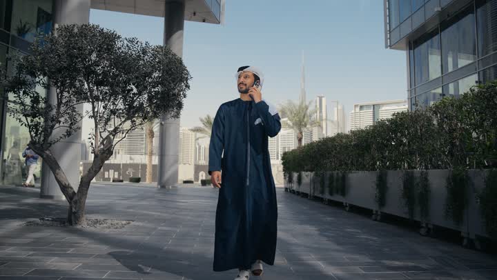 استخدام التكنولوجيا والتقنيات الحديثه ، الدردشة والتواصل مع العائلة ،إجراء مكالمه هاتفيه عبر الهاتف المحمول، رجل عربي خليجي اماراتي يقضي أوقات ممتعة في إحدى الحدائق في الامارات ، جولة في الطبيعة، نزهه في الهواء الطلق، سماع الاخبار والمفاجأت السعيدة