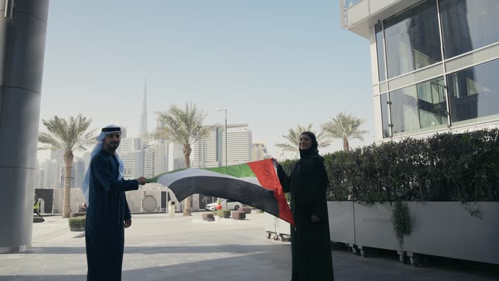 حب الوطن والانتماء إليه, الاحتفال باليوم الوطني 2 ديسمبر، يوم استقلال الإمارات ، التعرف على ثقافات وتاريخ شعب الامارات، تصوير لزوجان يرتديان الزى الاماراتي يمسكان علم دولة الامارات العربية المتحدة
