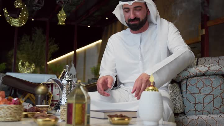الاجتهاد في العبادة، تلاوة وقراءة القرآن الكريم وتدبر معانيه، الشعور بالخشوع والطمأنينة، شاب عربي خليجي اماراتي يرتدي الكندوره والغتره يحمل بيده المصحف الشريف، الإكثار من ذكر الله تعالى، التقرب الى الله في شهر رمضان