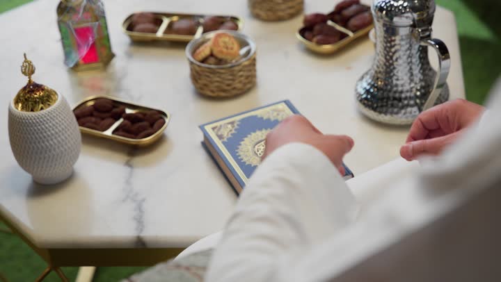 الإكثار من ذكر الله تعالى، تلاوة وقراءة القرآن الكريم وتدبر معانيه، الاجتهاد في العبادة، الشعور بالخشوع والطمأنينة، شاب عربي خليجي اماراتي يرتدي الكندوره والغتره يحمل بيده المصحف الشريف،  التقرب الى الله في شهر رمضان
