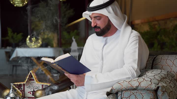 الإكثار من ذكر الله تعالى، تلاوة وقراءة القرآن الكريم وتدبر معانيه، الشعور بالخشوع والطمأنينة، الجلوس فى احدي الشاليهات الاماراتيه ، الاجتهاد في العبادة، شاب عربي خليجي اماراتي يرتدي الكندوره والغتره يحمل بيده المصحف الشريف، التقرب الى الله في شهر رمضان