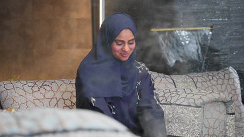 الجلوس فى احدي الشاليهات الاماراتيه ، أدعية وأذكار، تلاوة وتحفيظ القرآن الكريم ، زينة شهر رمضان، المناسبات الدينية والأعياد الإسلامية، قراءة القرآن الكريم، امراه عربية خليجية اماراتيه ترتدي العباءه والحجاب تمسك بيدها كتاب الله تعالي ، إستقبال شهر رمضان، أجواء رمضانية، جلسات خارجية في الهواء الطلق