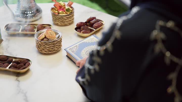 إستقبال شهر رمضان، أجواء رمضانية ،كتاب الله تعالى ، تلاوة وتحفيظ القرآن الكريم ، جلسات خارجية في الهواء الطلق ، أدعية وأذكار، زينة شهر رمضان، المناسبات الدينية والأعياد الإسلامية، قراءة القرآن الكريم، امراه عربية خليجية اماراتيه ترتدي العباءه والحجاب تمسك بيدها القران الكريم