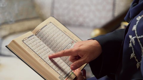 المناسبات الدينية والأعياد الإسلامية، امراه عربية خليجية اماراتيه ترتدي العباءه والحجاب تمسك بيدها القران الكريم ، إستقبال شهر رمضان، أجواء رمضانية ،كتاب الله تعالى ، تلاوة وتحفيظ القرآن الكريم ، جلسات خارجية في الهواء الطلق ، أدعية وأذكار، زينة شهر رمضان، قراءة القرآن الكريم