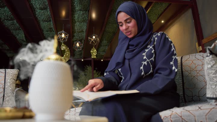 زينة شهر رمضان، المناسبات الدينية والأعياد الإسلامية، قراءة القرآن الكريم، أدعية وأذكار، تلاوة وتحفيظ القرآن الكريم ، امراه عربية خليجية اماراتيه ترتدي العباءه والحجاب ، إستقبال شهر رمضان، أجواء رمضانية، جلسات خارجية في الهواء الطلق