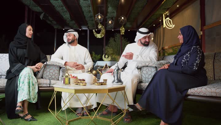 قضاء وقت ممتع مع العائله في الهواء الطلق ، بناء علاقات اجتماعيه ، عائله عربيه خليجيه اماراتيه تجلس في شاليه سياحي يقومون بتبادل الاحاديث بتعابير السرور، حسن الاستقبال وكرم الضيافة في شهر رمضان المبارك، الاستمتاع بتناول المشروبات الباردة ، زينة وديكور رمضاني