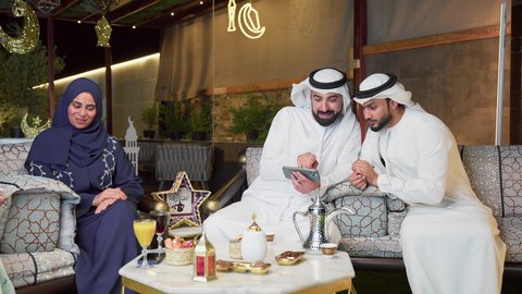 زينة وديكور رمضاني، قضاء وقت ممتع مع العائله في الهواء الطلق، حسن الاستقبال وكرم الضيافة في شهر رمضان المبارك، عائله عربيه خليجيه اماراتيه تجلس في شاليه سياحي يقومون بتبادل الاحاديث بتعابير السرور، الاستمتاع بتناول المشروبات الباردة