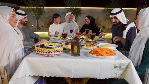 ايماءات السعادة والسرور، نقاش وحوار عائلي، مائده طعام مليئه بأصناف المأكولات و المقبلات الشهية، ديكور وأجواء رمضانية، تصويرلتجمع أسرة عربية خليجية اماراتية حول سفرة الإفطار في شهر رمضان المبارك