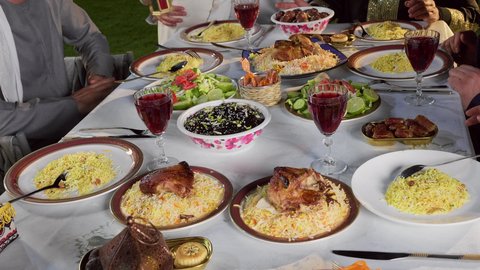 ديكور وأجواء رمضانية، نقاش وحوار عائلي، مائده طعام مليئه بأصناف المأكولات و المقبلات الشهية، تجمع أسرة عربية خليجية اماراتية حول سفرة الإفطار في شهر رمضان المبارك، طفل خليجي يمسك الفانوس بايماءات السعاده و السرور