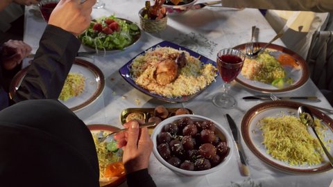 قضاء أوقات ممتعة مع الاسرة، وليمة طعام مليئة بالوجبات المتنوعة، التجمعات العائلية في شهر رمضان , صورة مقربة لعائلة عربية خليجية اماراتية يجلسون على مائدة الطعام المليئة بأصناف المأكولات والمشروبات المتنوعة والشهية