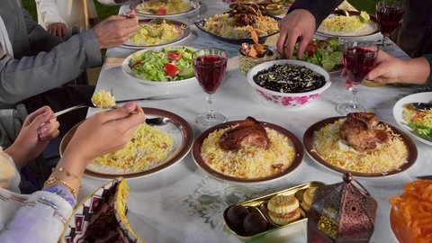 اجتماع الأسرة حول مائدة الطعام، أجواء دينية رمضانية، سفرة مليئة باصناف من المأكولات و المشروبات الشهية، تصوير مقرب لايدي اسره عربيه خليجيه اماراتية يقومون بتناول الطعام الشهي، أداء فريضة الصيام
