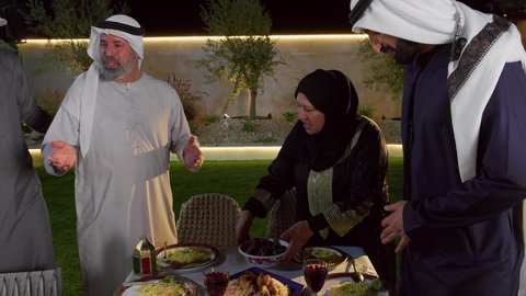 أجواء دينية رمضانية، سفرة مليئة باصناف من المأكولات و المشروبات الشهية، تصويرمقرب لاسره عربيه خليجيه اماراتية يقومون بالاستعداد لتناول الافطارالشهي، اجتماع الأسرة حول مائدة الطعام، أداء فريضة الصيام