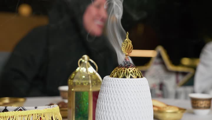 مبخرة تقليدية مزخرفة, التعطر والتطيب باطيب الروائح والعطور، أصالة العادات والتقاليد في الامارات المتحده، منظر الدخان المنتشر، ديكورات زينه رمضان، امرأه سعوديه تتحدث الي احد ما، منتج محلي وطني اماراتي، امرأه اماراتيه ترتدي عباءه سوداء تشير الي شئ ما