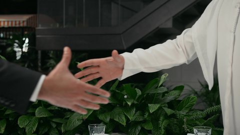 صداقة وتعارف وبناء علاقات اجتماعية، مفهوم الاستقبال والترحيب، إلقاء التحيه والسلام, تصوير مقرب لأيدي رجلان عربيان خليجيان اماراتيان يتصافحان، جلسة هادئة في كافيه راقي في الإمارات العربية المتحدة