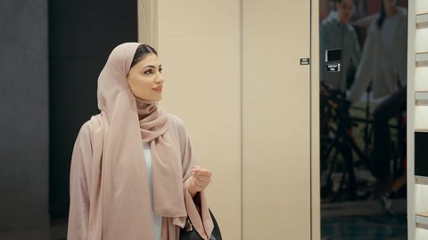 مفهوم التبضع و شراء الاكسسورات ، اقتناء نظارات حماية من الشمس، مجموعه من نظارات الشمسية في محل خليجي، تصوير مقرب  لامراة عربيه خليجيه اماراتية ترتدي العباءه الملونه تقوم باختيار نظاره شمسيه من الارفف المعروضه، سيده سعوديه تقوم بالتسوق داخل المول