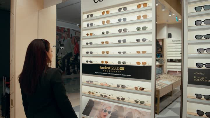 A wide new selection of eyeglasses in a Gulf store, how to choose sunglasses that suit your facial features, buying sun protection glasses, a photo from behind of a Gulf saleswoman displaying sunglasses