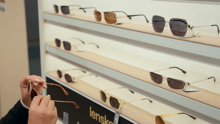A wide new selection of eyeglasses in a Gulf store, how to choose sunglasses that suit your facial features, buying sun protection glasses, a close-up of a Gulf seller displaying sunglasses