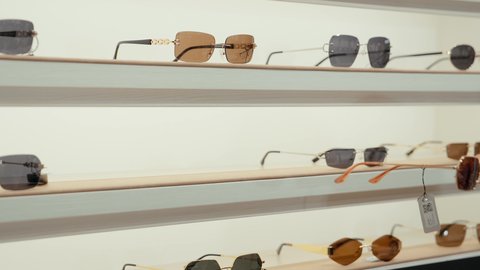 تشكيلة واسعة جديدة من نظارات النظر في محل خليجي،  كيفية إختيار النظارة الشمسية الملائمة لملامح الوجه ، اقتناء نظارات حماية من الشمس، تصويرمقرب ليد بائعه خليجيه تقوم بعرض النظارات الشمسيه