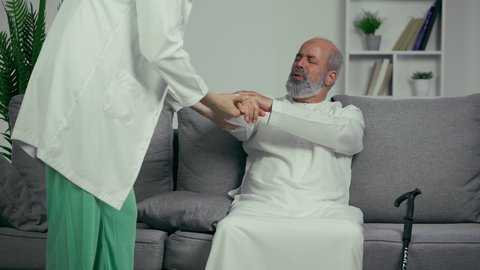 مريض عربي اماراتي كبير بالسن يشكو من آلام في الساعد واليد , يقوم الطبيب بفحص المريض والتأكد من سلامة اليد, صحة وأطباء , حالة مرضية , مهن ووظائف طبيه