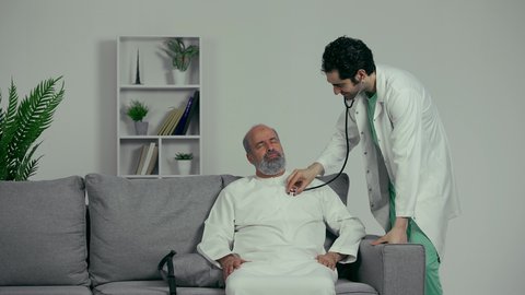 مفهوم الطب والرعاية الصحية، طبيب عربي اماراتي خليجي يرتدي المعطف الأبيض يقوم بسماع دقات القلب للتأكد من سلامة المريض، تقديم الخدمات العلاجية للمرضى بكل كفاءة، مهن ووظائف طبية، فحوصات وتشخيص نوبات القلب