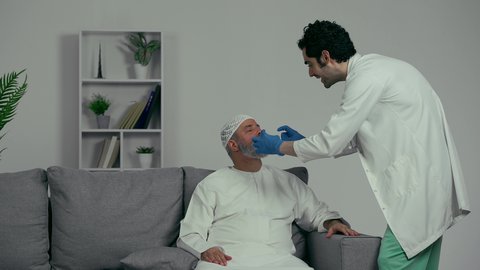 استخدام معدات وأدوات طب الأسنان، زيارة العيادات الصحية وإتخاذ الإجراءات اللازمة، الأساليب العلاجية المتبعة للعناية بالفم، معالجة التسوس وتركيب الحشوات،  طبيب عربي خليجي اماراتي يرتدي القفازات يقوم بفحص أسنان الرجل المسن