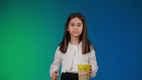 عدم معرفه شئ ما ،الاهتمام بالاناقه والمظهر الخارجي ،الابتعاد عن روتين الحياة اليومية، ايماءات الاستمتاع بمشاهدة فيلم ممتع، متابعة الأفلام والعروض المسرحية في السينما، تصوير لبنت عربية خليجية اماراتيه مبتسمة ترتدي الزي الكاجوال ونظاره سوداء تمسك بيدها علبه الفوشار ، خلفية ملونه