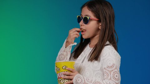 تحديد هدف معين ، الاشاره باصبع السبابه الى شئ ما ، متابعة الأفلام والعروض المسرحية في السينما، الابتعاد عن روتين الحياة اليومية، بورتريه لبنت عربية خليجية اماراتيه مبتسمة ترتدي الزي الكاجوال ونظاره سوداء تمسك بيدها علبه الفوشار ، ايماءات الاستمتاع بمشاهدة فيلم ممتع، خلفية ملونه