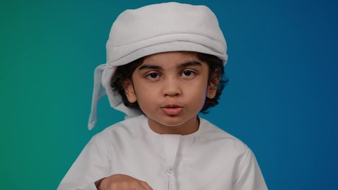 Entertainment computer programs, eating popcorn, having a good time playing video games, enjoying modern technology and techniques, the concept of fun and entertainment, close-up of a smiling Emirati Gulf Arab child holding a joystick, colorful background