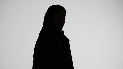 Reading notes and information, the concept of education and culture, writing research and reports, a silhouette of an Emirati Gulf Arab woman wearing an abaya and hijab, holding work papers, following up on plans and projects, white background